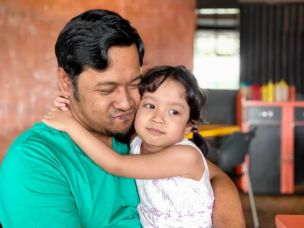 Father and daughter playing together at restaurant, enjoying togetherness