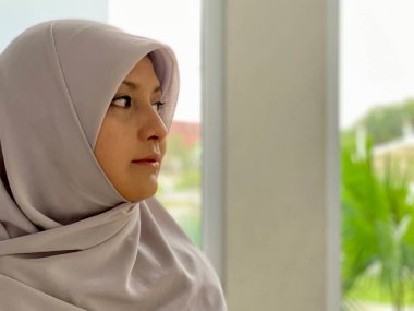 Portrait young woman wearing hijab looking away