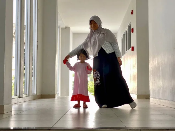 Sisters chatting playing together in a building hallway