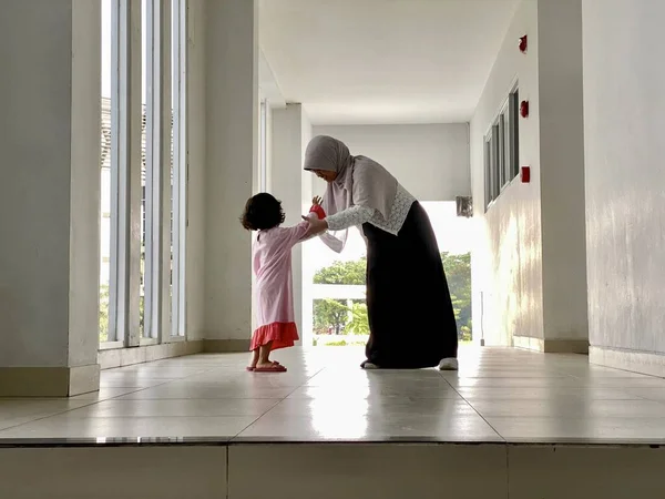 Sisters chatting playing together in a building hallway