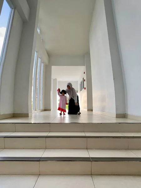 Sisters chatting playing together in a building hallway