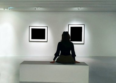 Sanat müzesindeki bankta oturan siyah elbiseli kadının arkası.