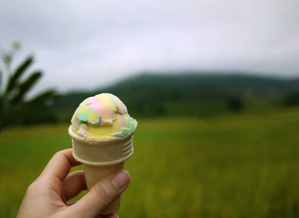 Close Hand Holding Rainbow Color Ice Cream Waffle Cone Blurry — Fotografia de Stock