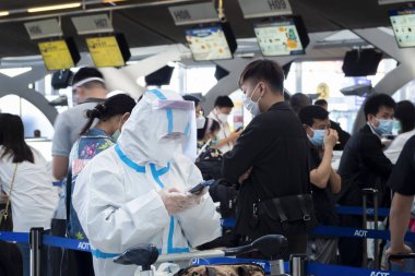 Bangkok, Tayland - 16 Ocak 2022: Suvarnabhumi havaalanı, Bangkok, Tayland 'a uçmadan önce kontrol etmek için elbise giyen Asyalı yolcular..
