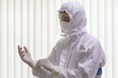 Pen giysisi giyen ve yüz maskesi takan doktor koronavirüs covid-19 PCR testi yapıyor. Doktor koruyucu eldivenler giyer ve yeni Omicron Covid 'le savaşmak için koruyucu kıyafet giyer. seçici odak.