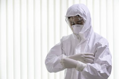 Pen giysisi giyen ve yüz maskesi takan doktor koronavirüs covid-19 PCR testi yapıyor. Doktor koruyucu eldivenler giyer ve yeni Omicron Covid 'le savaşmak için koruyucu kıyafet giyer. seçici odak.