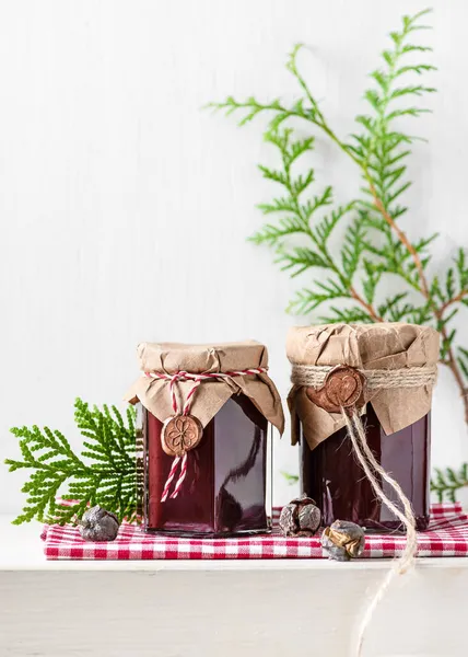 クリスマスのために小さなプレゼントとしてグランジペーパーとワックスシールで飾られたグラス瓶の中の自家製フルーツジャム キッチンギフトのアイデアコンセプト スペースのコピー — ストック写真