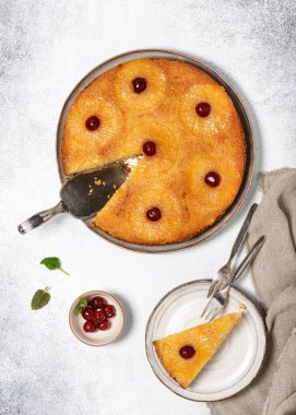 Piece of upside down pineapple cake with candied cherries and caramel. Homemade summer tropical dessert. Top view. 