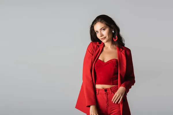 Mladá Trendy Žena Červeném Obleku Náušnice Pózovat Izolované Šedé — Stock fotografie