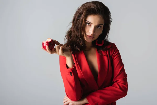 Gri Üzerinde Kırmızı Elma Tutan Şık Takım Elbiseli Esmer Kadın — Stok fotoğraf