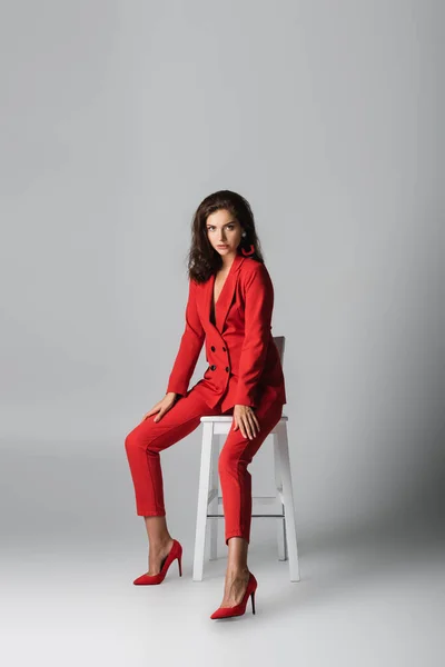 Comprimento Total Jovem Moda Terno Vermelho Posando Enquanto Sentado Cadeira — Fotografia de Stock