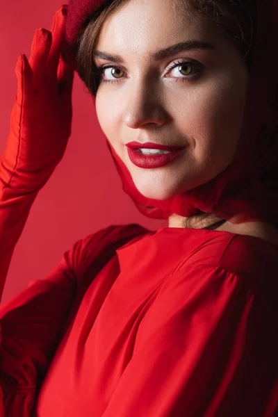 Cheerful Young Woman Glove Adjusting Beret Isolated Red — Stock Photo, Image