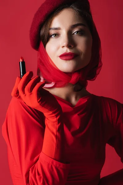 Ung Kvinna Slöja Och Basker Håller Läppstift Isolerad Rött — Stockfoto