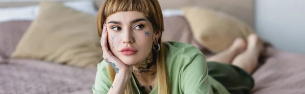 Ung Kvinna Med Tatuering Och Piercing Tittar Bort När Ligger — Stockfoto