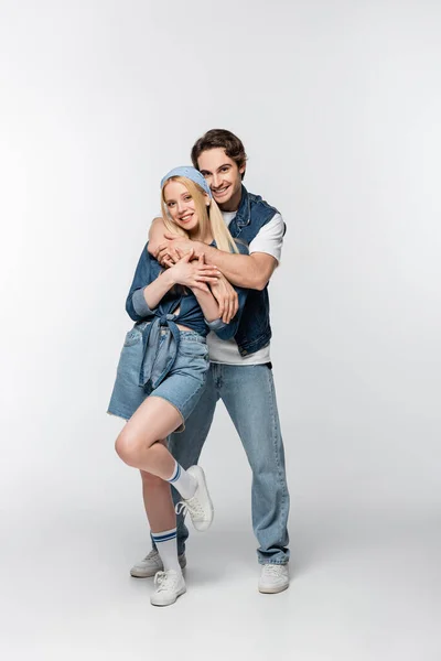 Happy Young Couple Denim Clothes Looking Camera While Embracing White — Stock Photo, Image