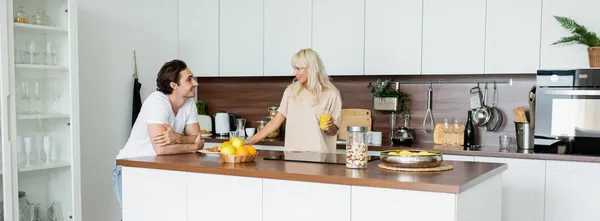 Homem Feliz Olhando Para Namorada Alegre Com Vidro Suco Laranja — Fotografia de Stock