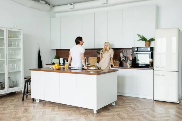 Happy Man Looking Girlfriend Eating Croissant Kitchen — Stock Photo, Image