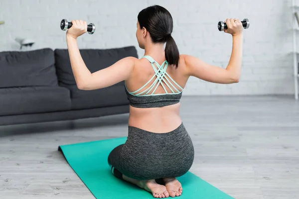 Visão Traseira Mulher Sportswear Exercício Com Halteres Enquanto Sentado Tapete — Fotografia de Stock