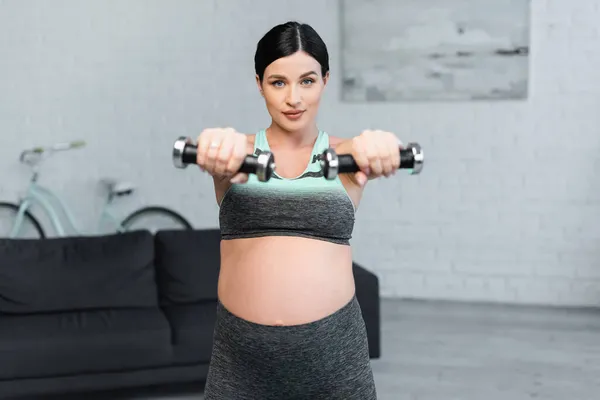 Jonge Zwangere Vrouw Kijken Naar Camera Tijdens Training Met Halters — Stockfoto