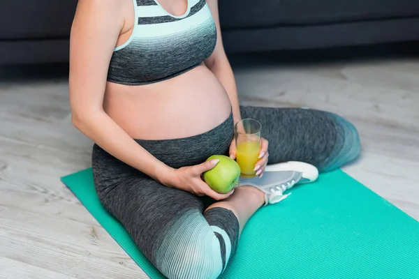 Beskärd Utsikt Över Gravida Kvinna Sportkläder Sittandes Träningsmatta Med Äpple — Stockfoto