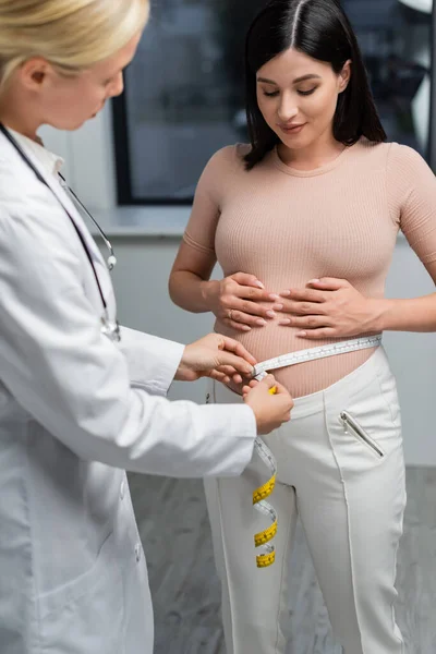 Blurred Doctor Estimating Size Belly Pregnant Woman Consulting Room — Stock Photo, Image