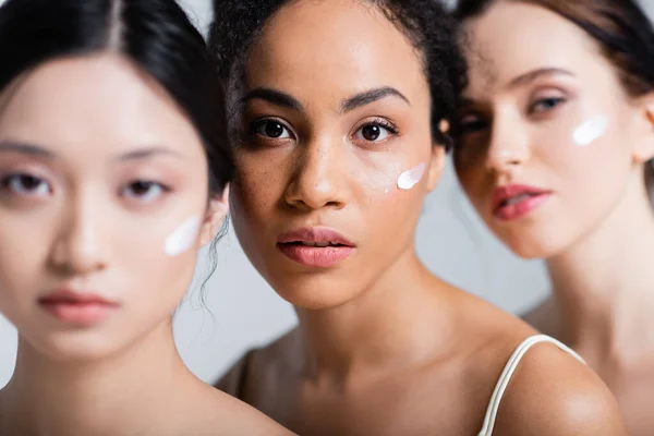 African American Woman Cream Face Looking Camera Blurred Interracial Friends — Stock Photo, Image