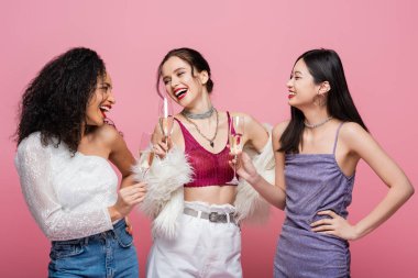 Parti sırasında şampanya içen çok kültürlü moda kadınlar pembe renkte izole edilmiş. 