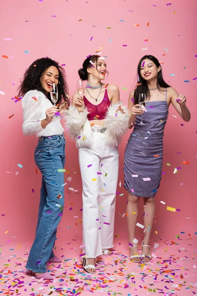 Wesołe Międzyrasowe Kobiety Szampanem Świętujące Nowy Rok Pod Konfetti Różowym — Zdjęcie stockowe