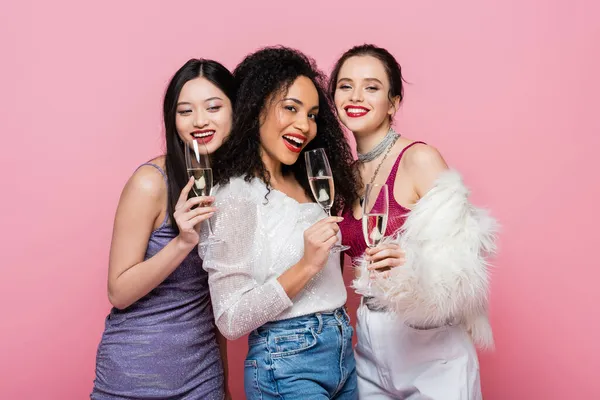 Mulheres Multiculturais Positivas Roupas Festivas Segurando Copos Champanhe Isolados Rosa — Fotografia de Stock