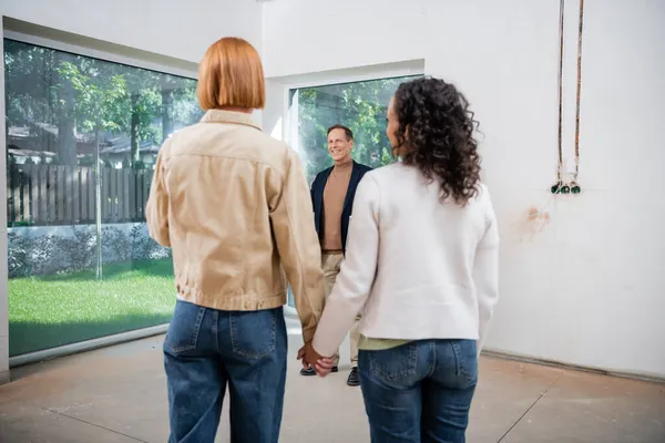 Cheerful Middle Aged Realtor Smiling Blurred Interracial Lesbian Couple Holding — Stock Photo, Image