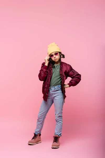 유행하는 소녀의 선글라스를 조정하고 색옷을 손으로 포즈를 취하는 — 스톡 사진