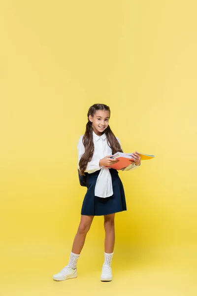 Cheerful Schoolgirl Holding Notebooks Looking Camera Yellow Background — Stock Photo, Image