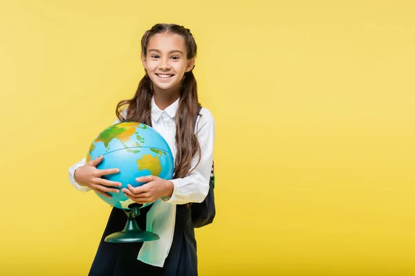 Gelukkig Schoolmeisje Holding Globe Kijken Naar Camera Geïsoleerd Geel — Stockfoto