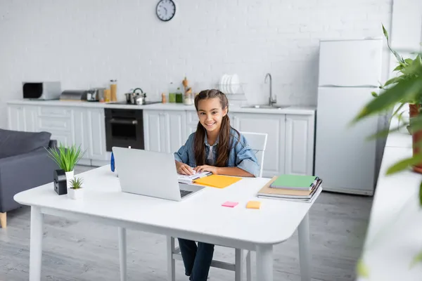 Niño Preadolescente Sonriendo Cámara Cerca Portátiles Portátil Cocina — Foto de Stock