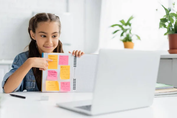 Schoolkid Pointing Notebook Sticky Notes Video Call Blurred Laptop Home — Stock Photo, Image