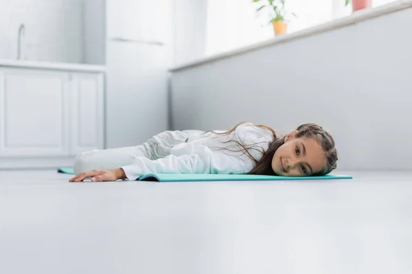 Nível Superfície Criança Sorridente Deitada Tapete Fitness Casa — Fotografia de Stock