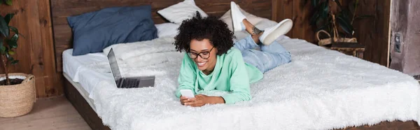 Mujer Afroamericana Feliz Anteojos Acostados Cama Mientras Utiliza Teléfono Inteligente — Foto de Stock