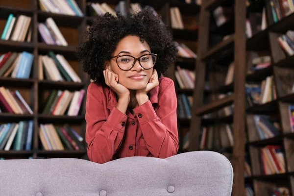 Happy African American Woman Eyeglasses Leaning Couch Looking Camera — Stock Photo, Image