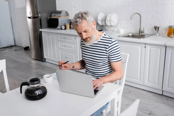 Reifer Mann Mit Stift Und Laptop Der Nähe Von Kaffee — Stockfoto