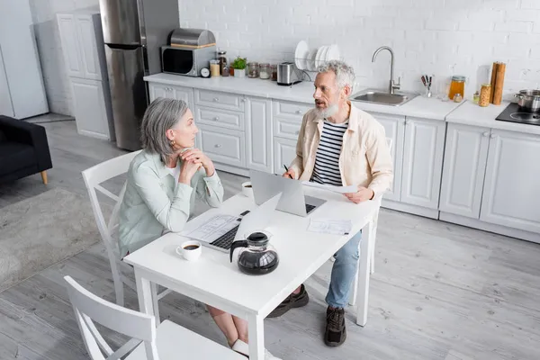 Grey Haired Mature Couple Bills Laptops Talking Kitchen — Stock Photo, Image