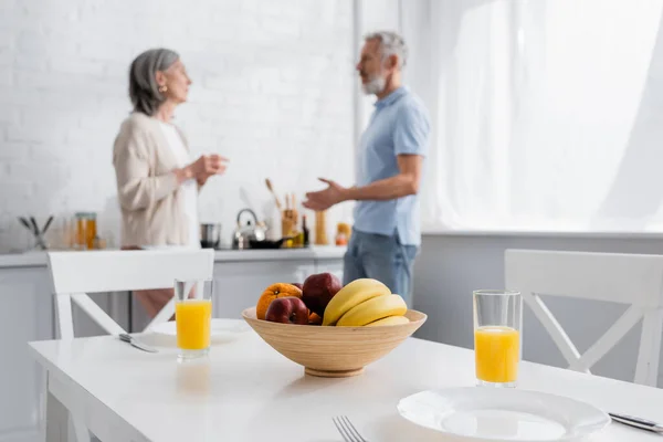 Fruits Orange Juice Table Blurred Mature Couple Kitchen — Stock Photo, Image