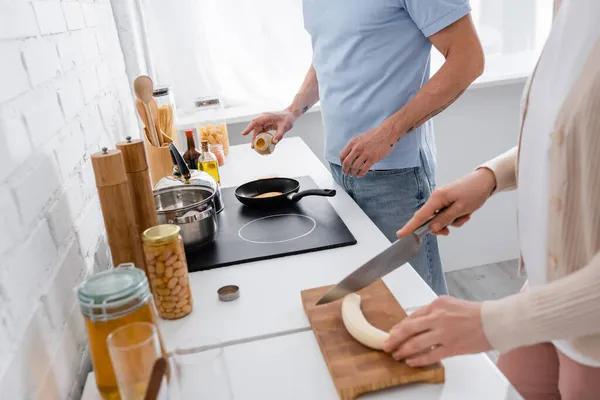 Cropped View Man Seasoning Pancake Frying Pan Wife Cutting Banana — Stock Photo, Image