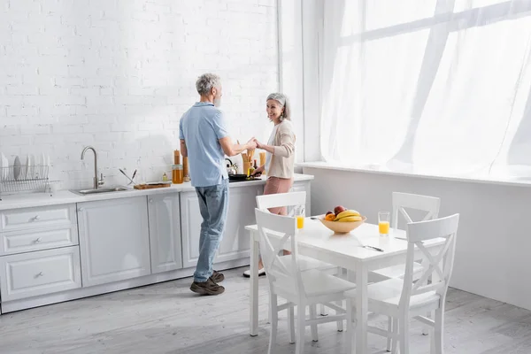Lachend Volwassen Paar Hand Hand Tijdens Het Koken Keuken — Stockfoto