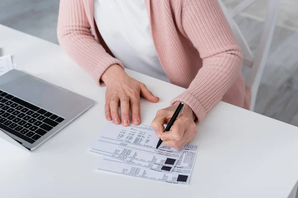 在家里的笔记本电脑旁 女性在账单上写字的剪影 — 图库照片