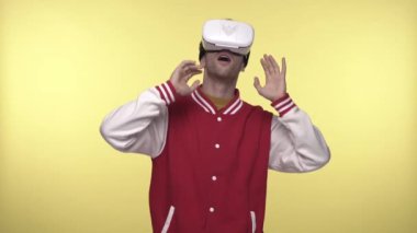 VR kulaklıklı, sarı kulaklıklı adam etrafa bakıyor. 