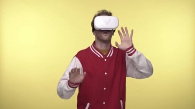VR kulaklıklı korkmuş adam sarıya işaret ediyor.