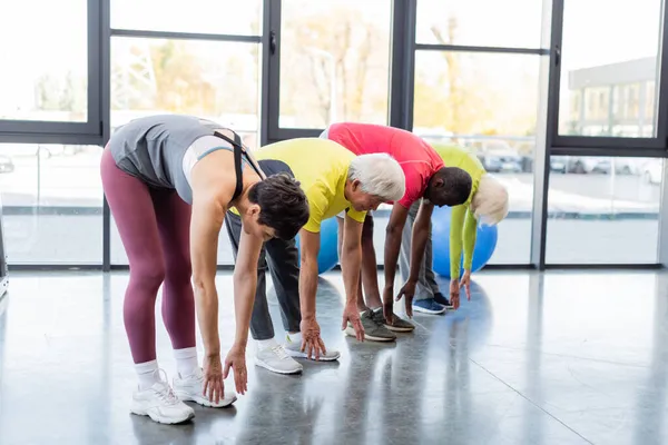 Grupo Personas Multiétnicas Que Estiran Juntas Gimnasio —  Fotos de Stock