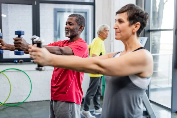 Deportista Afroamericana Haciendo Ejercicio Con Pesas Cerca Deportista Senior Centro — Foto de Stock