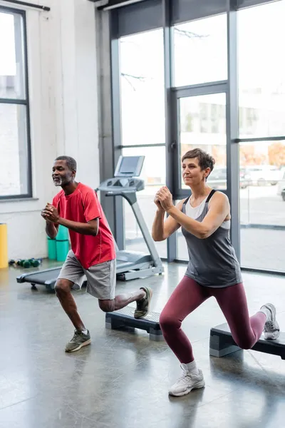 Senior Kvinna Tränar Med Aerobiska Steg Nära Afrikansk Amerikansk Vän — Stockfoto