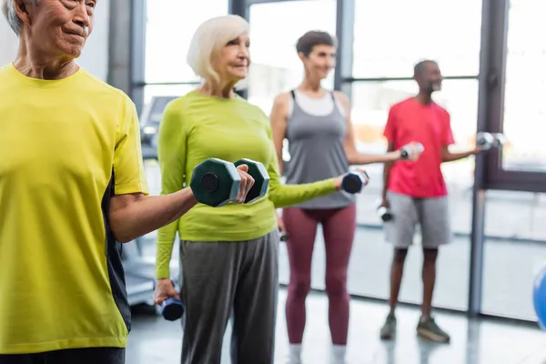 Asian Sportsman Holding Dumbbell Blurred People Gym — Stock Photo, Image